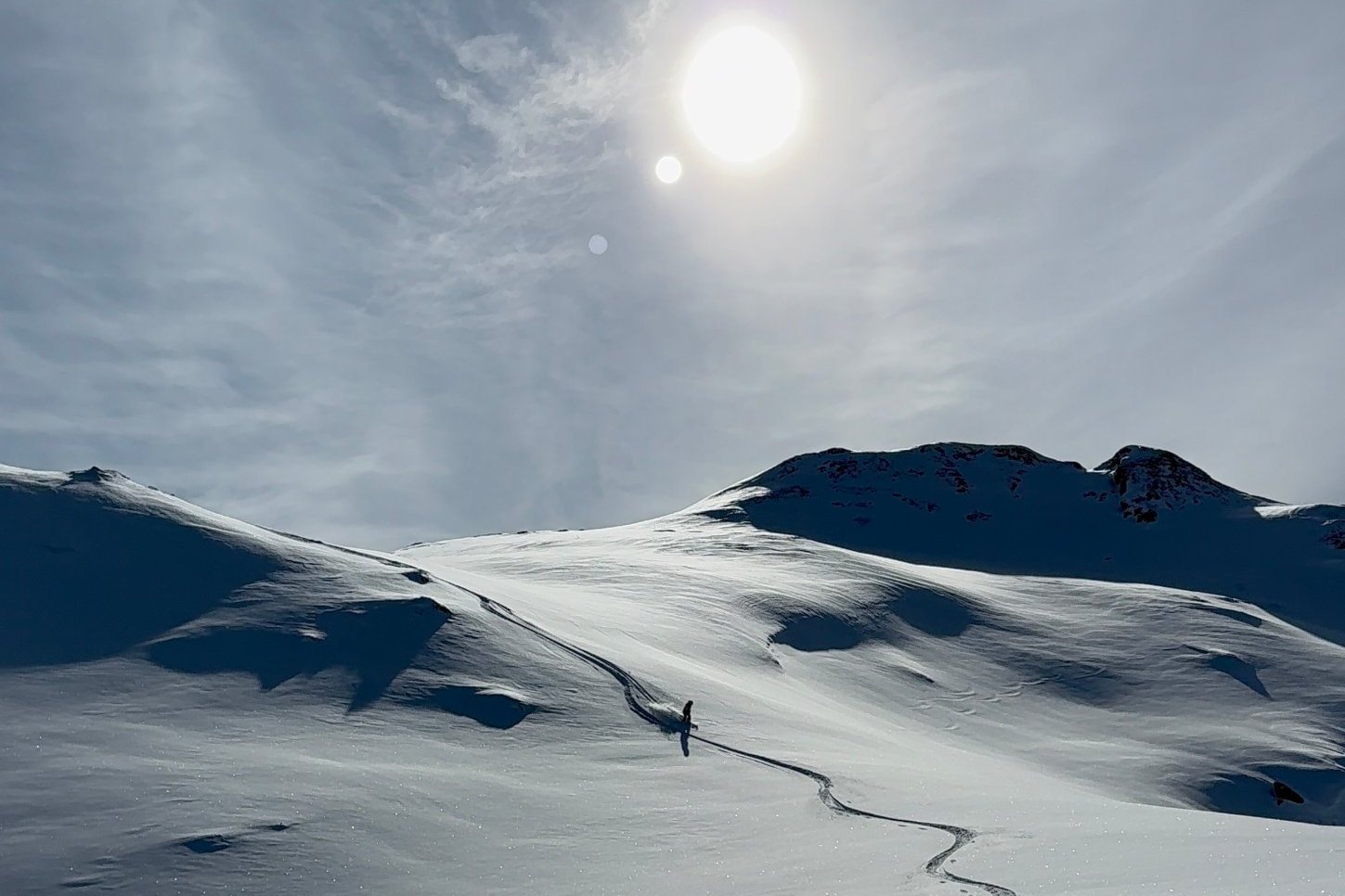 Traces d’un skieur dans la neige fraîche sous un soleil voilé, à Val d’Isère