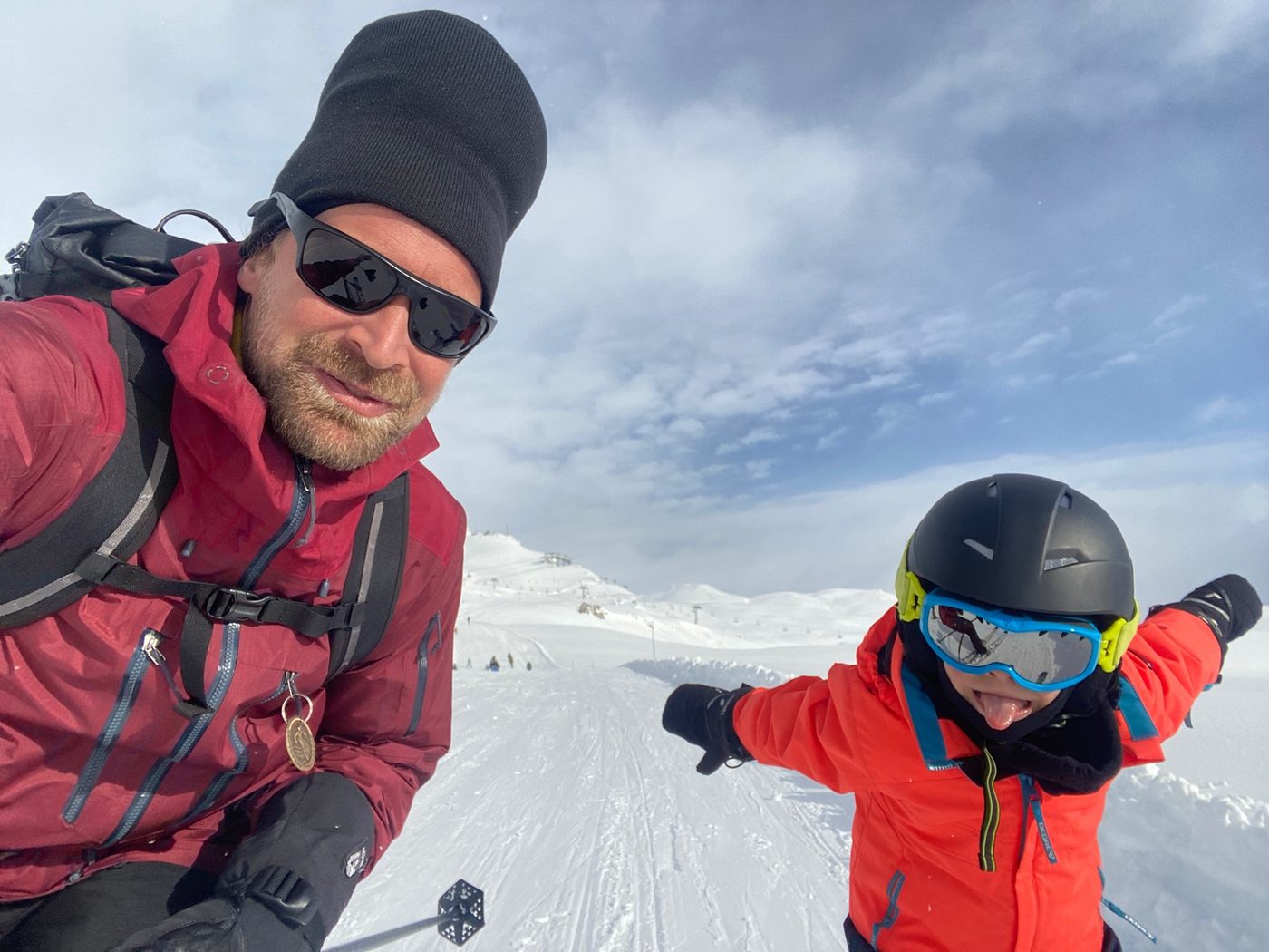 Ski instructor and young child having fun on the piste