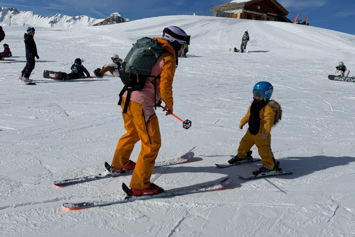 Ski instructor teaching a young child to ski on the slopes