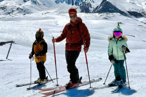Ski instructor with two children during a private ski lesson in the mountains